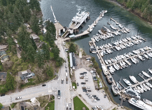 A hyperlapse of the ferry loading. Cars quickly load onto the ferry shot from a drone.